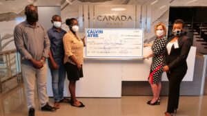 CAF Executive Director & Media Relations Specialist hand over check to Kairo's family